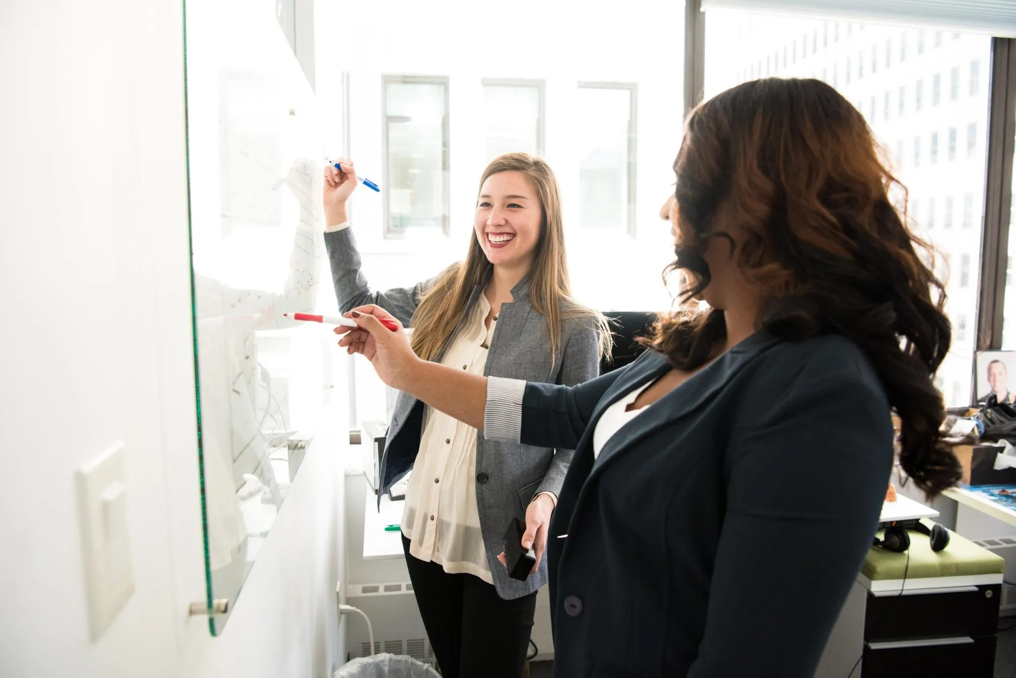 Two people planning at a whiteboard